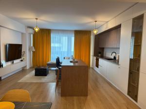a kitchen and living room with a table in a room at ABE Apartment in Craiova