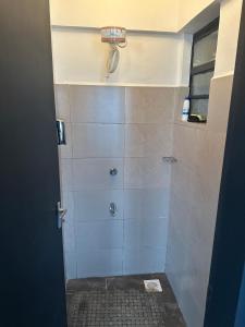 une salle de bain avec une douche avec une porte vitrée dans l'établissement The loft, à Kisumu