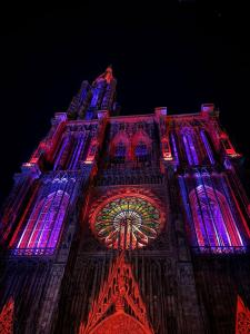 a lit up tower of a building with colorful lights at Strasbourg Centre et Parlement in Strasbourg