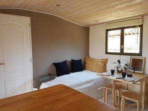 a small room with a bed and a table at la cabane des remparts in Marsac-en-Livradois