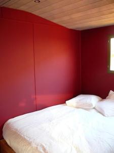 1 dormitorio con pared roja y cama blanca en Chateau de Riols, en Marsac-en-Livradois