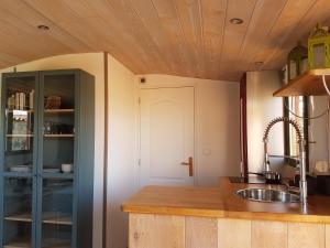 a kitchen with a sink and a wooden ceiling at la cabane des remparts in Marsac-en-Livradois