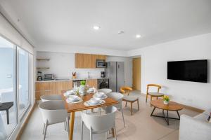 a dining room and kitchen with a table and chairs at Upstay Brand New 3BR Viva Jaco Residences in Jacó +24 photos