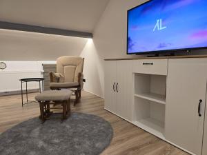 a living room with a flat screen tv and chairs at Suite à Saint-Hubert in Saint-Hubert