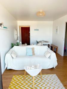 a living room with a white couch and a table at Cote et Mer Superbe appartement Front de Mer WIFI & PARKING in Villers-sur-Mer