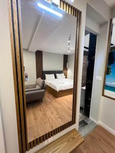einen Spiegel in einem Zimmer mit einem Bett und einem Sofa in der Unterkunft Suite apartment in Korçë