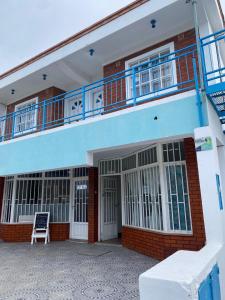 ein blaues Gebäude mit einem Balkon und einem Stuhl in der Unterkunft Complejo Gago DTO 1 in Puerto Madryn + 18 Fotos