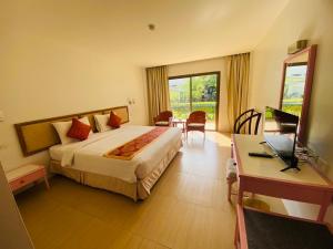 a hotel room with a bed and a desk with a laptop at Nautical Inn in Pattaya +59 photos