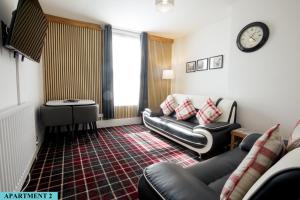 sala de estar con sofá, silla y reloj en St Luke's 2, en Liverpool