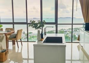 a white kitchen with a view of the ocean at Beach Penthouse - 3 BR, Jacuzzi, Marriott pool access in Ban Ko Kok