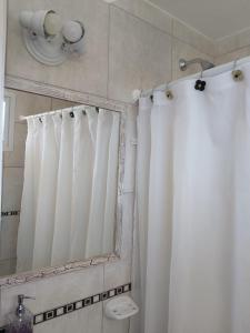 a bathroom with a shower curtain and a mirror at Monoambiente Italia in Venado Tuerto