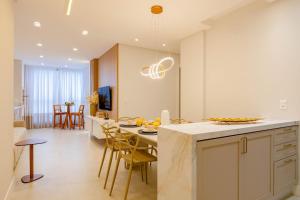 a kitchen and living room with a table and chairs at Belissimo apto alto padrão a 50 mts da praia in Bombas +14 photos