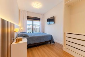 a bedroom with a bed and a window at Belissimo apto alto padrão a 50 mts da praia in Bombas