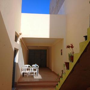 a hallway with a table and chairs in a building at Tayrt Hostel in Mirleft