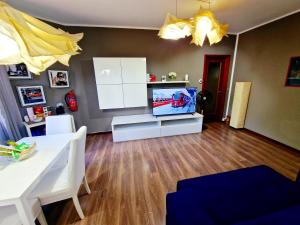 a living room with a flat screen tv and a table at BERNINA STATION CENTRE APARTMENT 2 - One minute walk from bernina station in Tirano