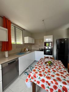 a kitchen with a table with a flower pattern on it at Villa du coeur in Deshaies