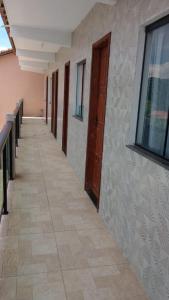 a hallway of a building with a door and a tile floor at Casa para temporada, São Pedro da Aldeia - RJ in São Pedro da Aldeia