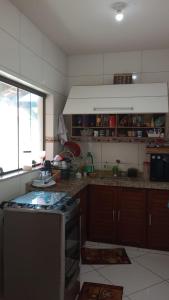 a kitchen with a stove top oven next to a window at Casa para temporada, São Pedro da Aldeia - RJ in São Pedro da Aldeia