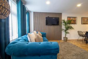 a blue couch in a living room with a television at Modern 2-Bed Apt, Private Parking, Ayr Town Centre in Ayr