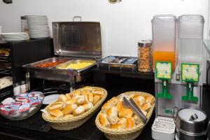 um buffet com cestas de pão e outros alimentos em Hotel America do Sul em São Paulo