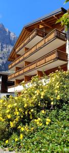 a building with a bunch of yellow flowers in front of it at Altrove Leukerbad - Modern, Spacious & Central in Leukerbad +49 photos