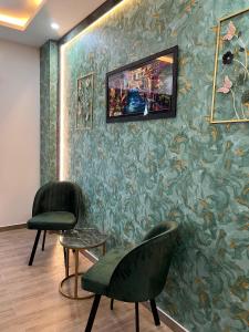 a waiting room with two chairs and a wall with a painting at Eleven Height 3 in Rawalpindi +5 photos