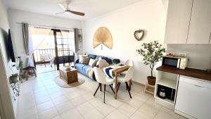 a living room with a blue couch and a table at Sunset Oasis on the Beach in Costa Del Silencio