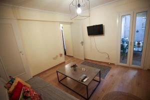 a living room with a coffee table and a tv at Sunny Garden Apartment in central kolonaki Athens in Athens