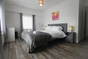 a bedroom with a large bed and wooden floors at Windsor Stays 2 in Liverpool