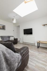 a living room with a couch and a flat screen tv at Windsor Stays 2 in Liverpool