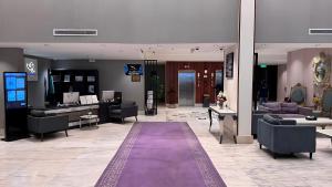 Eine Lobby mit Sofas und einem lila Teppich in der Unterkunft شقق كيان للشقق المخدومة in Abha