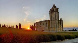 an old church with a clock tower at sunset at Victoria Stay Terraza Vistas y Garaje incluido in Alcalá la Real