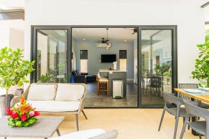 a living room with sliding glass doors and a dining room at Serenity Surf Villa in Playa Grande
