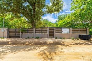 a fence with a tree in the background at Serenity Surf Villa in Playa Grande
