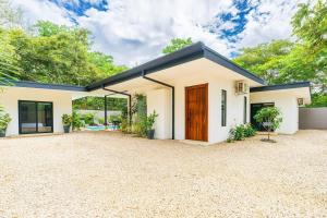 a house with a large driveway in front of it at Serenity Surf Villa in Playa Grande +40 photos