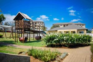 a playground in a park with a slide at CozyHome Near Airport with pool gym and 24hour security in Boksburg