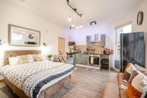 a bedroom with a large bed and a couch at Luxury Industrial Studio Leeds Near Brudenell social club & Headingley Stadium in Headingley