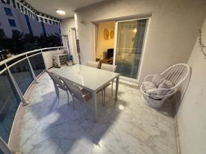 a white table and chairs on a balcony at Bonito apartamento de la playa in Villajoyosa