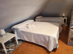 a bedroom with two beds with towels on them at Apartamento en Buhardilla de Casa Andaluza in Bollullos de la Mitación +27 photos