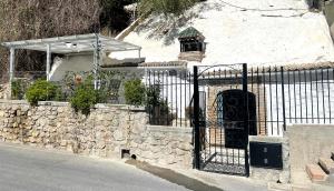 a building with a gate and a stone wall at CUEVA DE DAVID in Granada