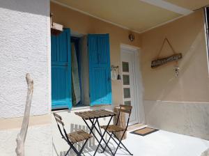 a patio with blue shutters and a table and chairs at La dimora del castagno in Ormea