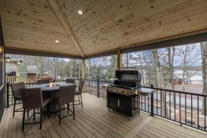 a screened porch with a grill and a table and chairs at New Lakeview Gateway Lake Access, Hot tub, EV in Lake Harmony