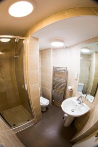 uma casa de banho com um chuveiro, um lavatório e um WC. em The Anvil Inn em Blandford Forum