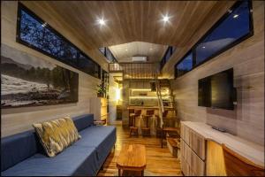 a living room with a blue couch and a tv at Casita VNV in Nosara
