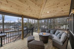 a screened in porch with a couch and a table at New Lakeview Gateway Lake Access, Hot tub, EV in Lake Harmony