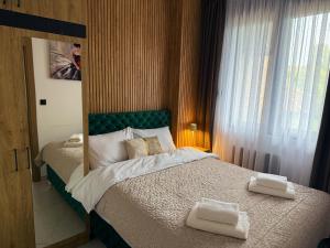 a bedroom with a bed with two towels on it at Crystal Everest Apartments in Vrdnik