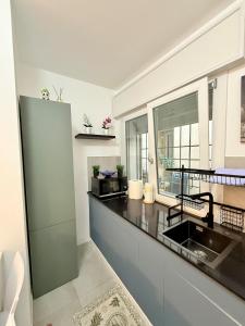 a white kitchen with a sink and a window at Casa AntoLeo - Borgo Casale Vicenza Centro in Vicenza