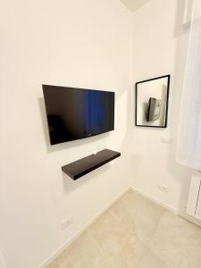 a flat screen tv hanging on a white wall at Casa AntoLeo - Borgo Casale Vicenza Centro in Vicenza +37 photos