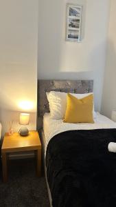 une chambre avec un lit et une table avec une lampe dans l'établissement Jarrow Haven Contractor Family Stay with FREE Parking Sleeps 8, à Jarrow