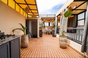 a balcony with potted plants and a table at Riad La Kasbah secrète in Marrakech